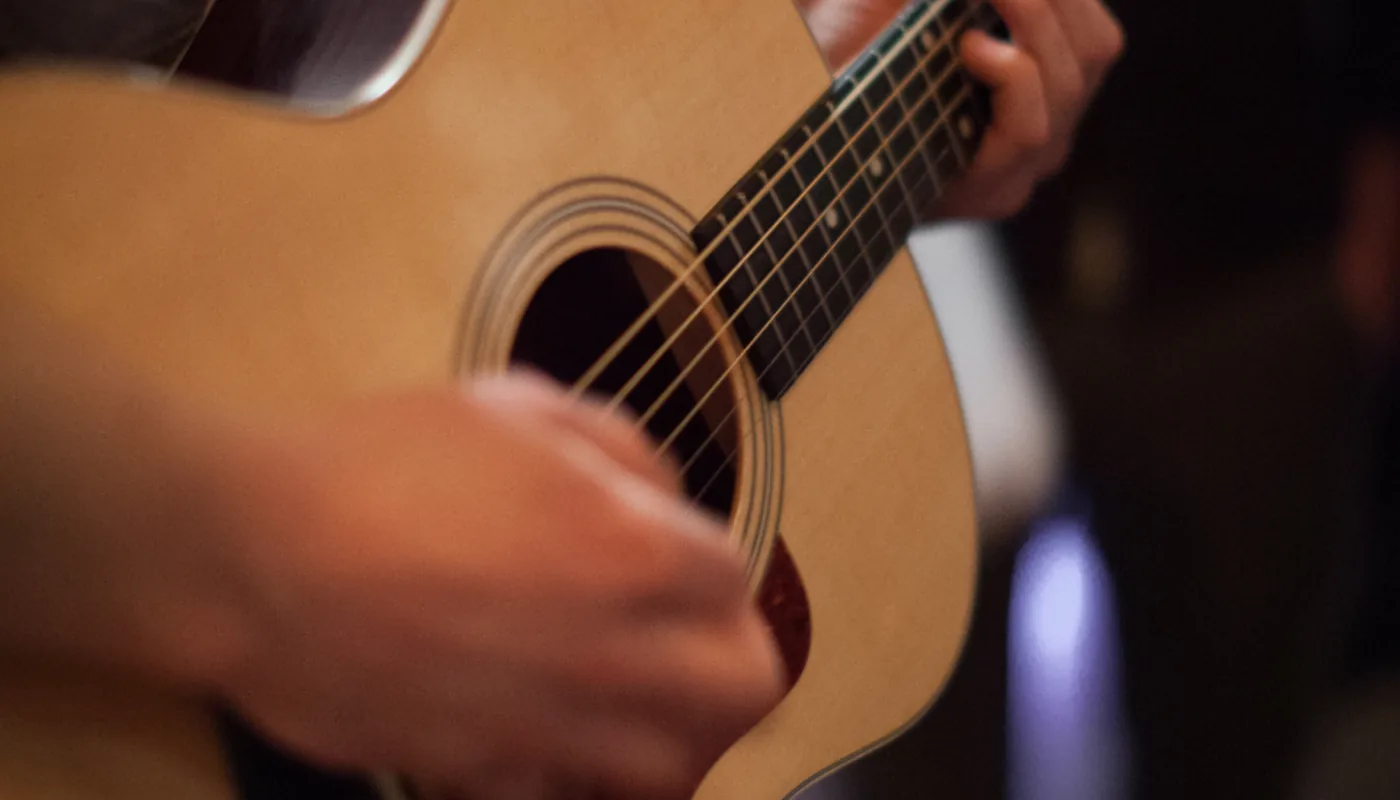 Tangan memetik gitar akustik di Nada Wetan