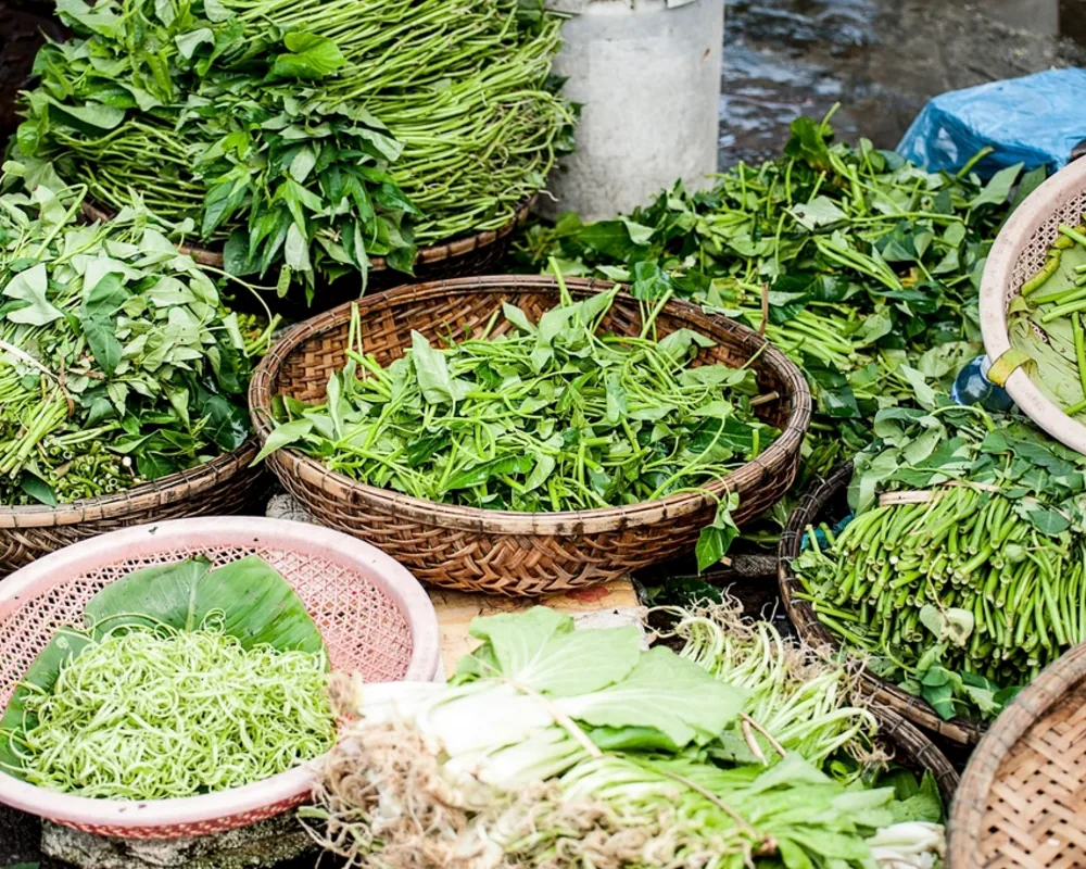 Keranjang sayuran hijau tertata di los pasar