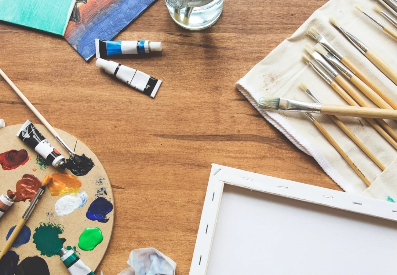 Meja lukis dengan palet dan kuas di Ruang Warna